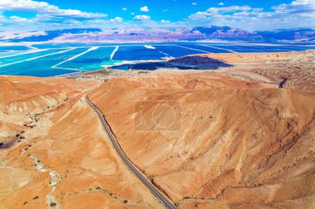 Téléchargez les photos : Désert de Judée sur les rives de la mer Morte. Collines sèches sans eau d'argile jaunâtre et beige. De magnifiques routes sont posées entre les collines. Tir à partir d'un drone, d'une vue d'oiseau. Israël - en image libre de droit