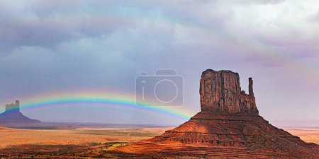 The famous rock Mitten. Gorgeous bright rainbow all over the sky. Monument Valley is a unique geological formation in Arizona and Utah. USA. Navajo Indian Reservations. 
