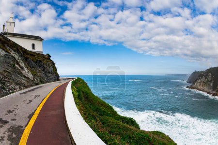 Schöne Straße zur Wachturmkapelle und zum Leuchtturm. Der majestätische Atlantik. Asturien. Romantische Reise nach Spanien. Ungewöhnlich beeindruckende Architektur der Luarca. 