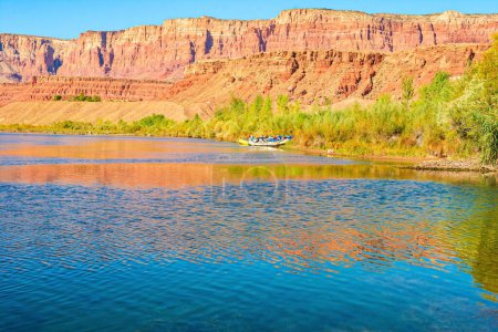 The multicolored canyon of orange and yellow Navajo sandstones. The water of the Colorado River reflects the steep rocks. The historic Lees Ferry on the Colorado River.