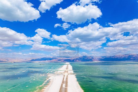 Das Tote Meer. Das verdunstete Salz wird auf dem Wasser gesammelt. Wolkenschatten spiegeln sich im Wasser wider. Resort für Entspannung und Behandlung. Israel. Drohnenfilme.