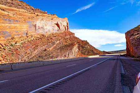 Téléchargez les photos : De majestueux paysages brun-rouge sont entrecoupés d'étroits canyons multicolores. L'autoroute asphaltée lisse court entre les crêtes pittoresques de la San Rafael Ree - en image libre de droit