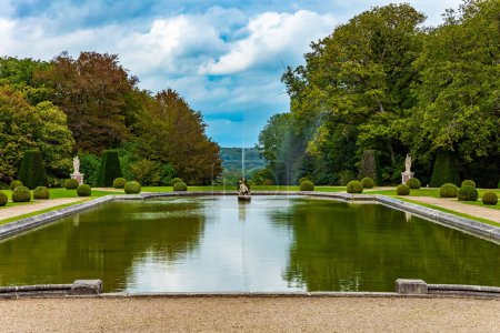 Der Kater in Stiefeln. Frankreich. Riesiges rechteckiges Schwimmbad mit Springbrunnen im Park. Schöner Park umgibt das alte Schloss von Breteuil. 
