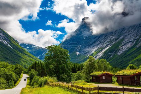 Camino escénico en las montañas. Precioso tiempo soleado en Noruega. Maravillosa vegetación verde fresca y exuberantes nubes blancas como la nieve. Viaje a la fabulosa Escandinavia.