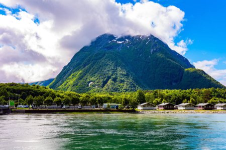 Gorgeous sunny weather in Norway. Huge, lovely lake surrounded by picturesque round hills. Wonderful fresh green vegetation and lush snow-white clouds