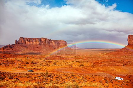 The famous rock Sentinel Mesa. The bright rainbow all over the sky. USA. Navajo Indian Reservations.  Monument Valley is a unique geological formation in Arizona and Utah. 