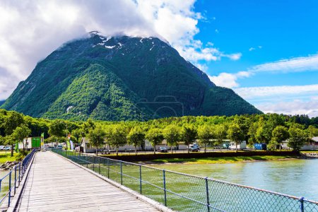 Bridge over the lake. Huge, lovely lake surrounded by picturesque round hills. Gorgeous sunny weather in Norway. Wonderful fresh green forest
