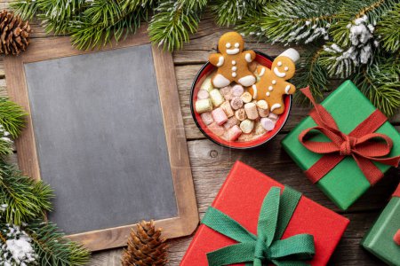 Téléchargez les photos : Biscuits au pain d'épice dans une tasse avec guimauve. Vacances de Noël avec tableau pour l'espace de copie - en image libre de droit