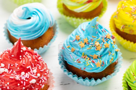 Foto de Cupcakes coloridos en mesa de madera - Imagen libre de derechos