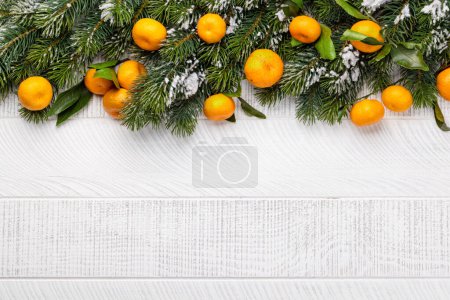 Foto de Decoración de la rama del árbol de Navidad y mandarinas maduras. Fondo plano de Navidad con espacio de copia - Imagen libre de derechos