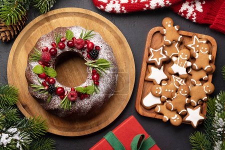 Foto de Pastel de Navidad decorado con semillas de granada, arándanos y romero. Puesta plana - Imagen libre de derechos