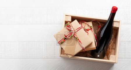 Christmas gift box with red wine bottle. Top view flat lay with space for your greetings