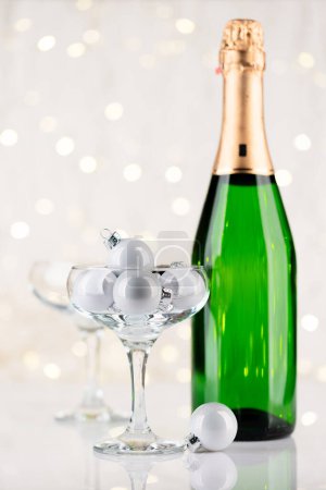 Téléchargez les photos : Bouteille de champagne et verres avec décor de Noël devant les lumières de Noël bokeh - en image libre de droit
