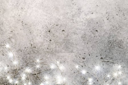 Téléchargez les photos : Guirlande lumineuse de Noël sur fond de pierre avec espace de copie - en image libre de droit