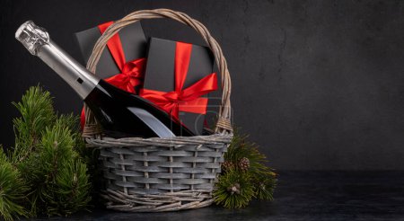 Photo for Basket with Christmas gift boxes and champagne and space for your Xmas greetings - Royalty Free Image