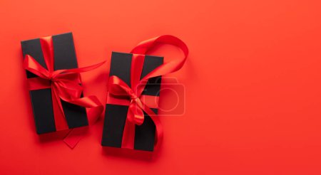 Téléchargez les photos : Carte Saint Valentin avec deux coffrets cadeaux. Sur fond rouge avec espace pour vos salutations - en image libre de droit