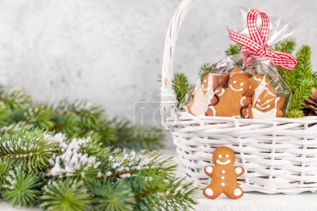 Téléchargez les photos : Panier avec biscuits au pain d'épice de Noël branches de sapin. Avec de l'espace pour vos salutations de Noël - en image libre de droit