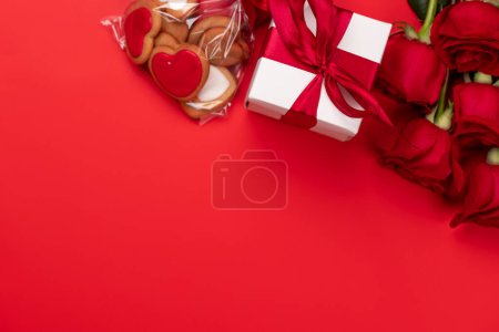 Téléchargez les photos : Carte Saint-Valentin avec coffret cadeau, biscuits en forme de coeur, fleurs roses et espace pour vos salutations - en image libre de droit