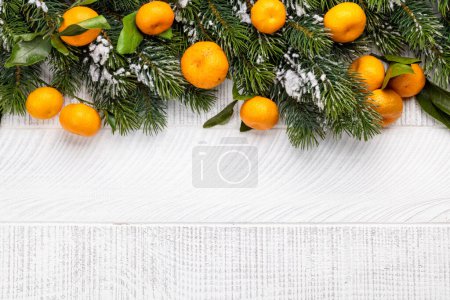 Téléchargez les photos : Décor de branche d'arbre de Noël et mandarines mûres. Fond plat de Noël avec espace de copie - en image libre de droit