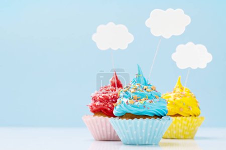 Foto de Coloridos cupcakes sobre fondo azul con espacio para copiar - Imagen libre de derechos