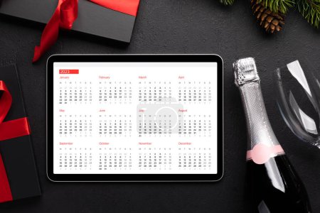 Téléchargez les photos : Tablette avec calendrier, coffrets cadeaux et décor de Noël. Modèle d'écran de périphérique de Noël - en image libre de droit