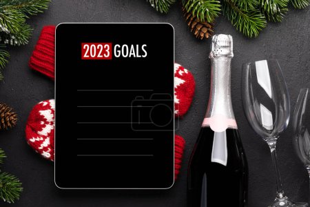 Foto de Tableta con plantilla de lista de goles, champán y decoración navideña. maqueta de pantalla del dispositivo de Navidad - Imagen libre de derechos