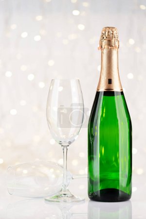 Photo for Champagne bottle and glasses in front of Christmas lights bokeh - Royalty Free Image