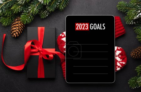 Photo for Tablet with goals list template, gift box and Christmas decor. Xmas device screen mockup - Royalty Free Image
