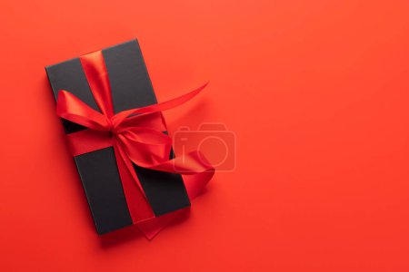 Téléchargez les photos : Carte Saint Valentin avec coffret cadeau. Sur fond rouge avec espace pour vos salutations - en image libre de droit