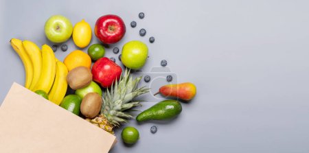 Photo for Shopping paper bag full of healthy fruits food on grey background. Flat lay with copy space - Royalty Free Image