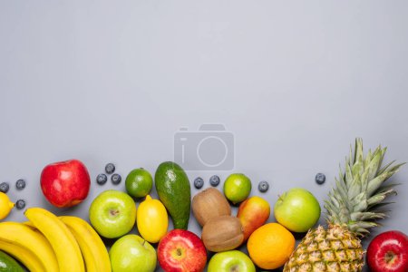 Téléchargez les photos : Fruits sains nourriture sur fond gris. Pose plate avec espace de copie - en image libre de droit