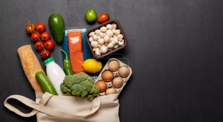 Photo for Shopping bag full of healthy food on dark background. Flat lay with copy space - Royalty Free Image