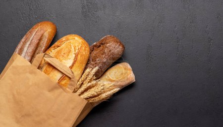 Photo for Fresh baked bread on stone table. Flat lay with copy space - Royalty Free Image