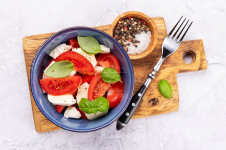Photo for Caprese salad with ripe tomatoes, mozzarella cheese and garden basil. Flat lay - Royalty Free Image