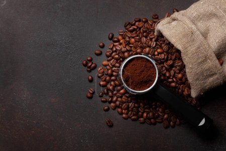 Téléchargez les photos : Grains de café torréfiés et café moulu dans le porte-filtre. Vue du dessus plat avec espace de copie - en image libre de droit