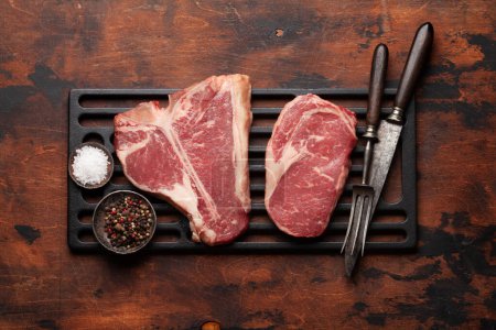 Téléchargez les photos : Divers steaks de bœuf cru. Porterhouse et Ribeye. Vue du dessus plat lay - en image libre de droit