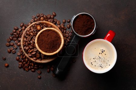 Photo for Roasted coffee beans, ground coffee in filter holder and espresso cup. Top view flat lay - Royalty Free Image