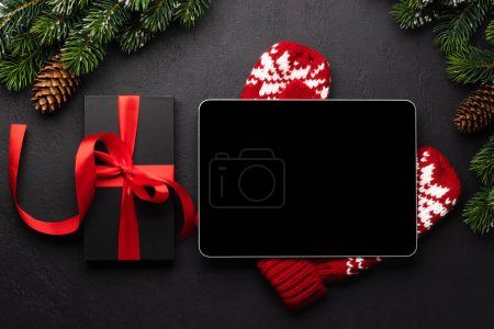 Foto de Tableta con pantalla en blanco, caja de regalo y decoración navideña. plantilla de pantalla de dispositivo de Navidad - Imagen libre de derechos
