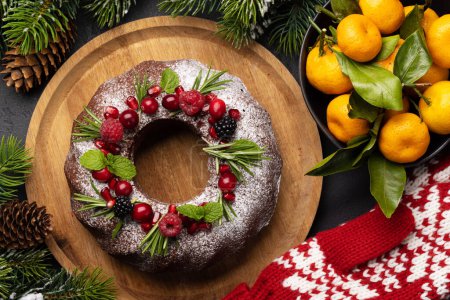Photo for Christmas cake decorated with pomegranate seeds, cranberries and rosemary. Flat lay - Royalty Free Image