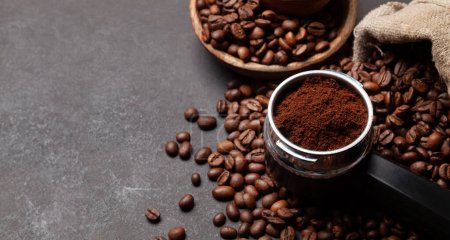 Téléchargez les photos : Grains de café torréfiés et café moulu dans le porte-filtre. Avec espace de copie - en image libre de droit