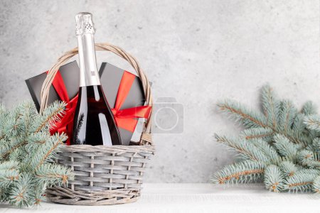 Foto de Cesta con cajas de regalo de Navidad y champán y espacio para sus saludos de Navidad - Imagen libre de derechos