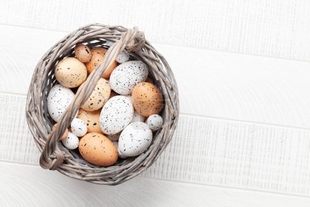 Photo for Easter greeting card with easter eggs in basket. Top view flat lay with copy space - Royalty Free Image
