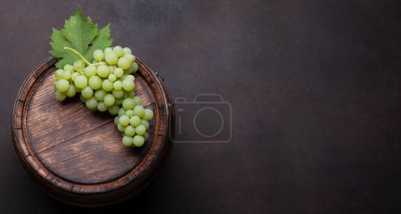 Téléchargez les photos : Raisin blanc sur vieux tonneau de vin en bois. Vue du dessus plat avec espace de copie - en image libre de droit