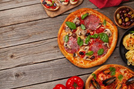 Téléchargez les photos : Cuisine italienne. Pâtes, pizza, olives et toasts antipasto. Pose plate avec espace de copie - en image libre de droit