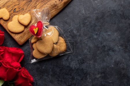 Téléchargez les photos : Carte Saint-Valentin avec biscuits en forme de coeur, fleurs roses. Pose plate avec espace de copie - en image libre de droit