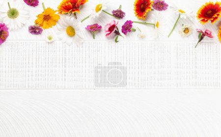 Téléchargez les photos : Diverses fleurs de jardin sur fond en bois. Vue du dessus plat avec espace de copie - en image libre de droit