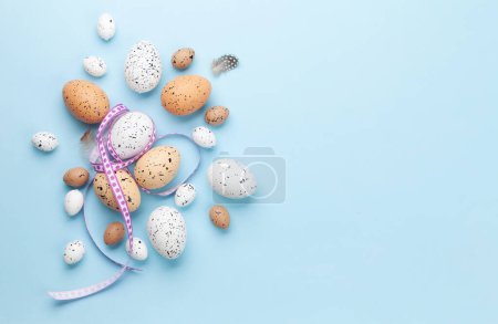 Photo for Easter greeting card with easter eggs on blue background. Top view flat lay with copy space - Royalty Free Image