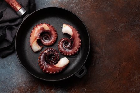 Photo for Grilled octopus with herbs and spices on frying pan. Top view flat lay - Royalty Free Image