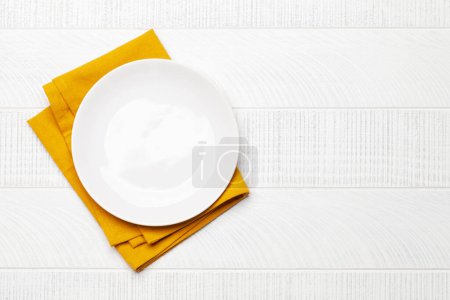 Téléchargez les photos : Assiette vide sur serviette sur table en bois. Vue de dessus plat couché avec espace de copie. Modèle ou maquette pour votre repas - en image libre de droit