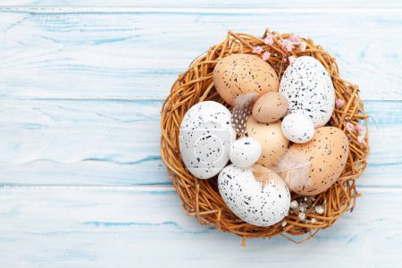 Téléchargez les photos : Carte de vœux de Pâques avec œufs de Pâques dans le nid. Vue du dessus plat avec espace de copie - en image libre de droit